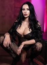 Watch busty Kimberlee stroke her massive thick cock while wearing a sexy catsuit